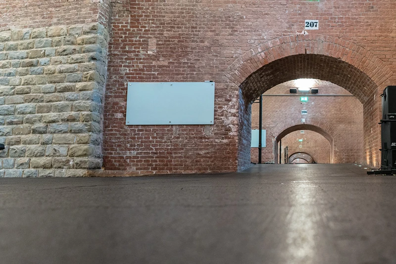 Classic brick hall designed for an event with a black exhibition floor with puzzle-tooth connection.