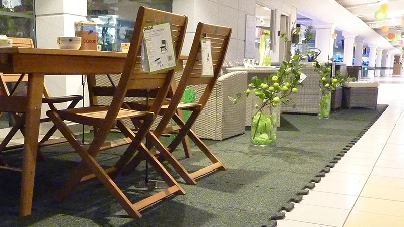 In the shopping centre, part of the tiled avenue was partitioned off for the special sale of garden furniture. The garden furniture stands on green exhibition floor click tiles.