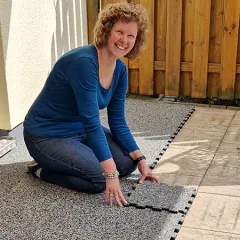 Domácí kutilka zde pokládá na svou terasu podlahu WARCO z PU pojeného gumového granulátu. Díky pevnému puzzle spojení lze elastické dlaždice rychle přizpůsobit a položit bez dalších nástrojů. Tento odolný a protiskluzový povrch chrání proti povětrnostním vlivům, zachovává si atraktivní vzhled a poskytuje vysoký komfort při chůzi.