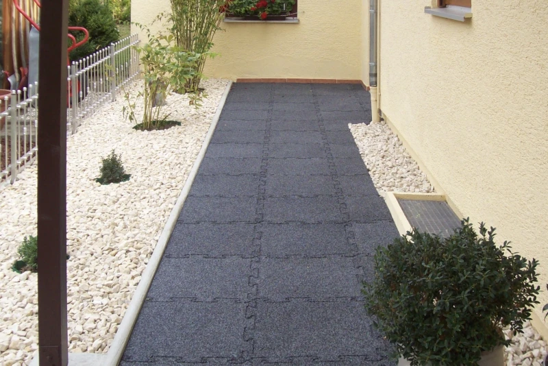 Slip-resistant and weatherproof WARCO rubber granulate paving slabs are laid on the path through the garden to the house entrance at the side of the house.